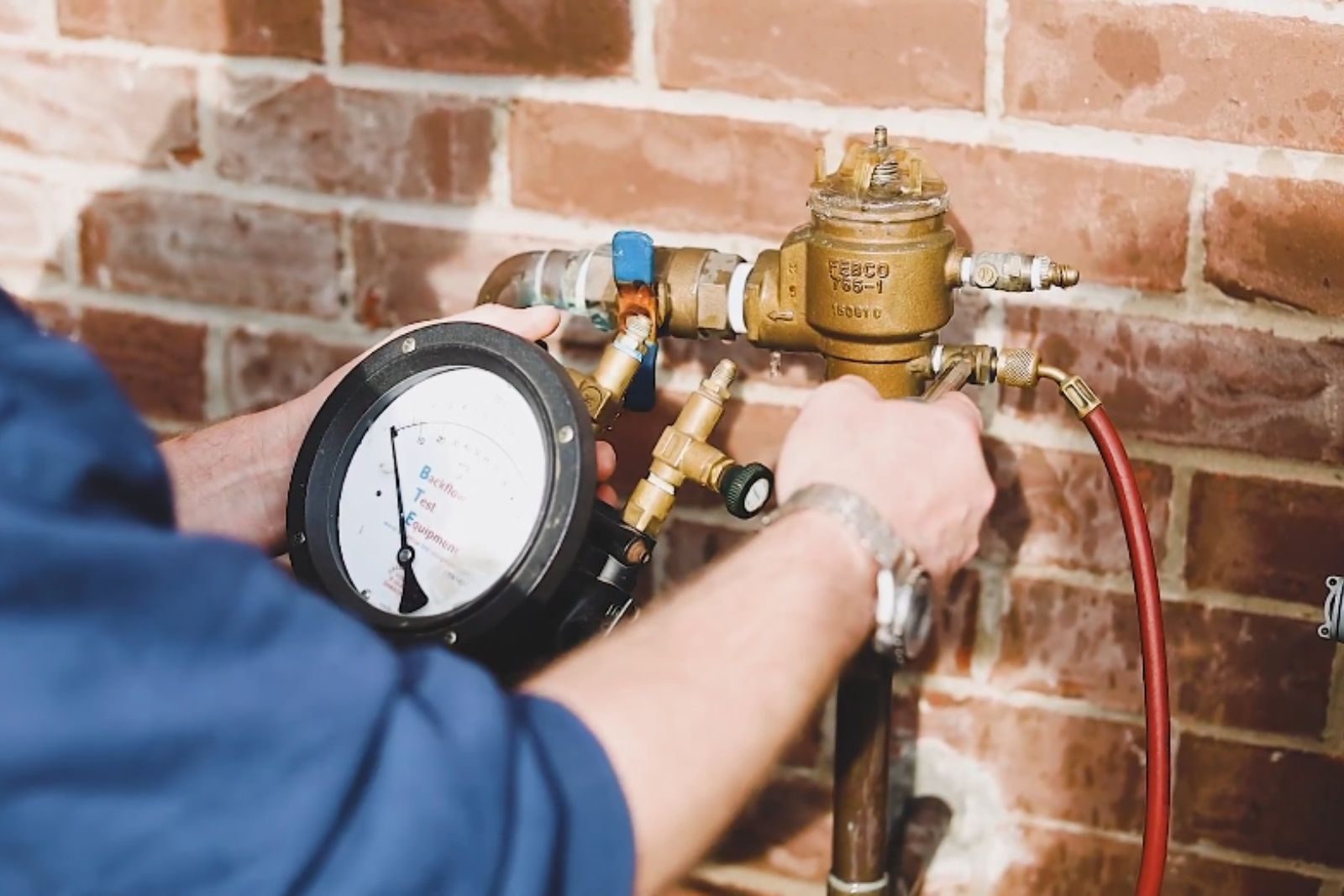 Plumber testing a backflow preventer device on a residential water line in Fort Myers, FL
