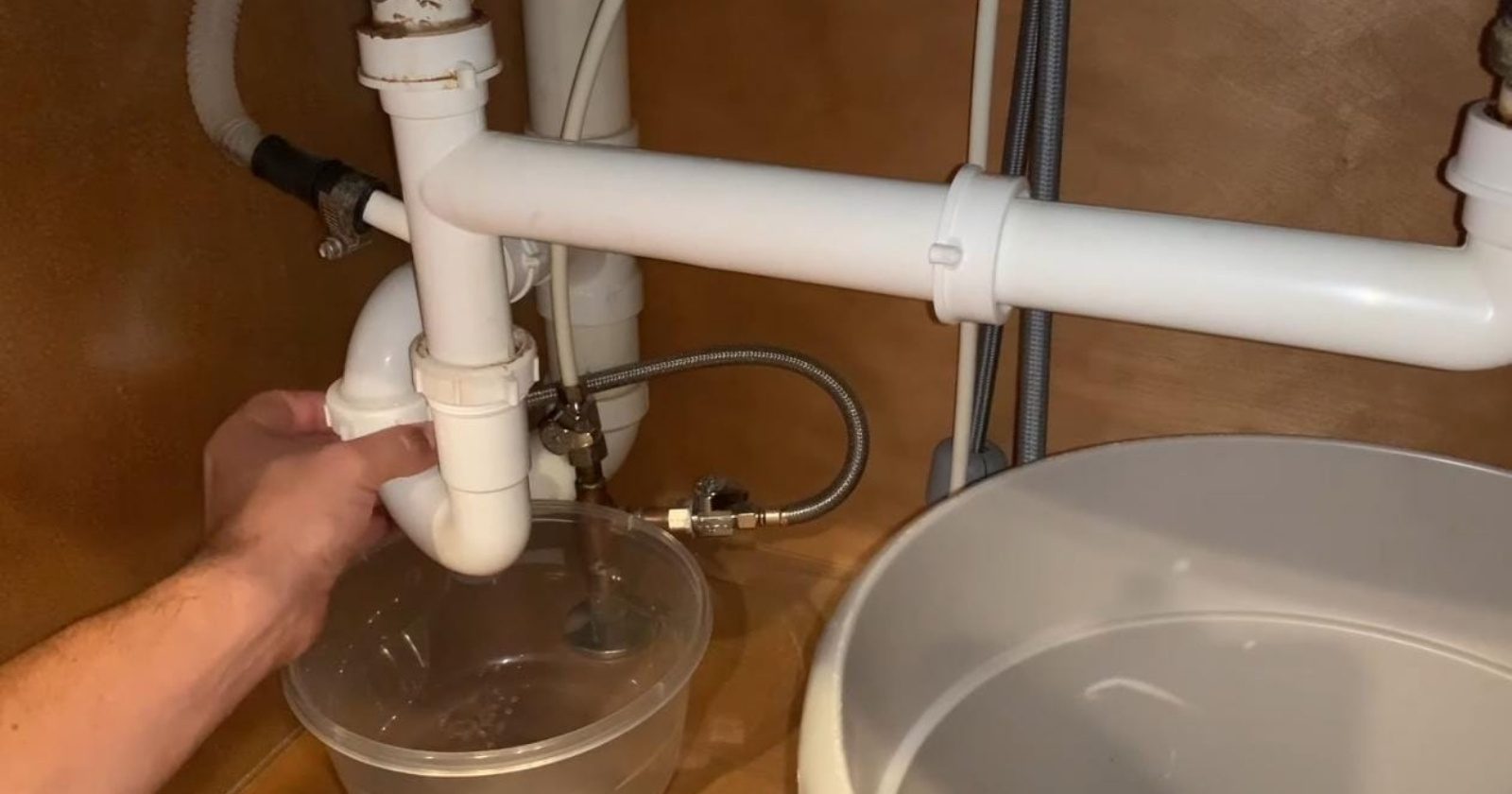 Licensed plumber repairing pipes under a kitchen sink in Fort Myers, FL