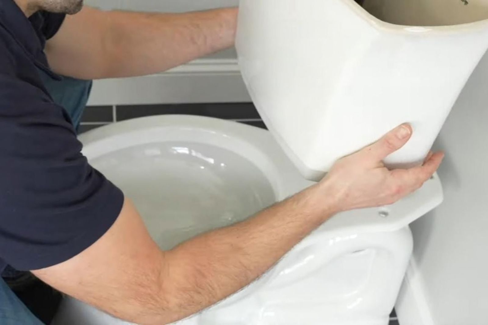 Plumber repairing a toilet in a Fort Myers, FL bathroom